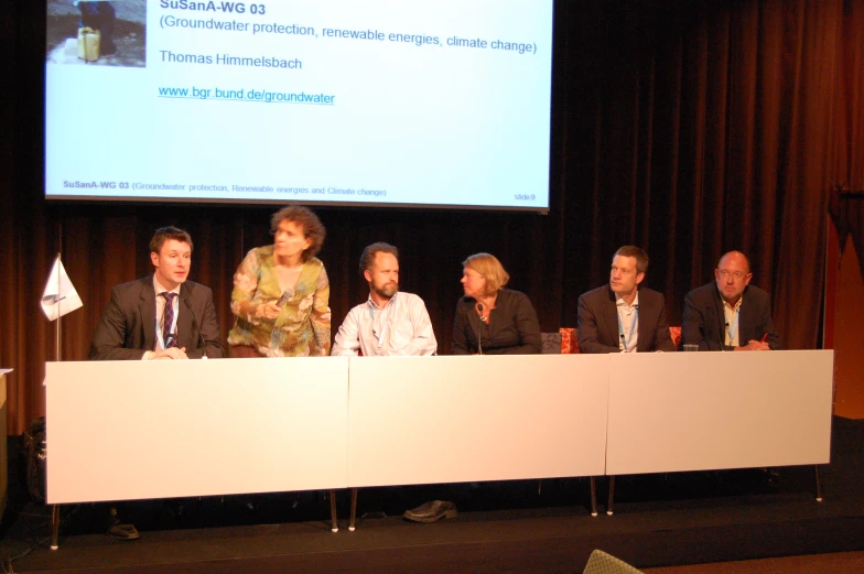 four people in front of a screen at a meeting