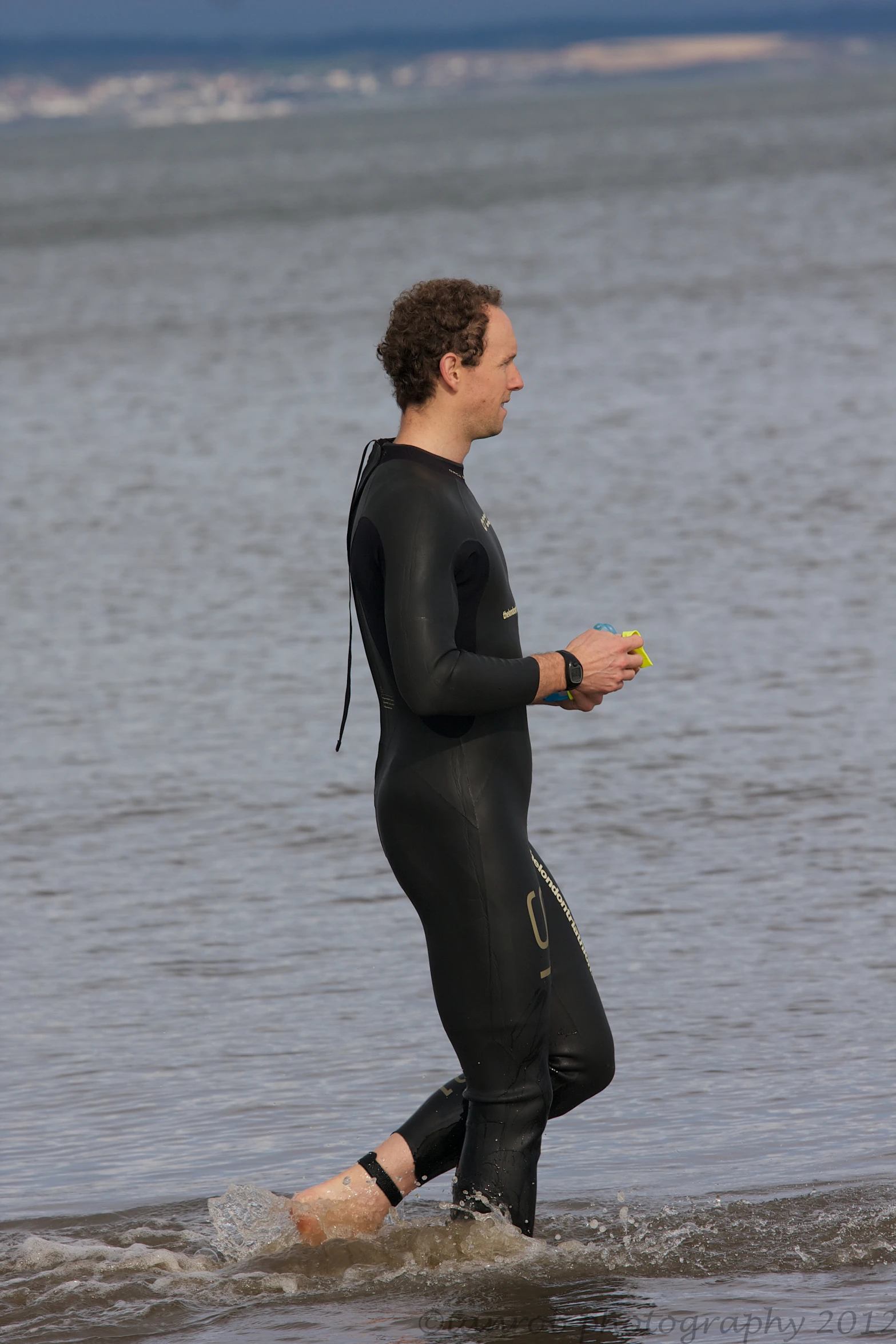 a man in wetsuit jogging through the water