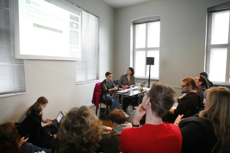 a group of people seated next to each other in a room