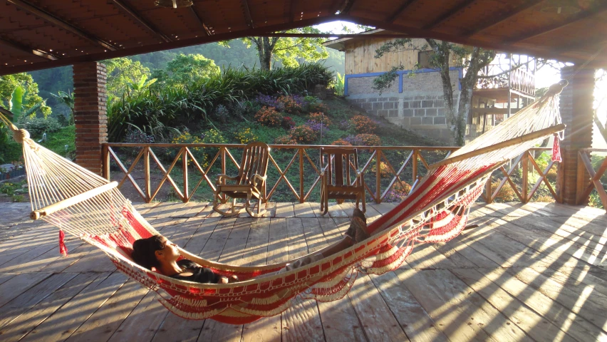 two persons on a hammock sitting outside