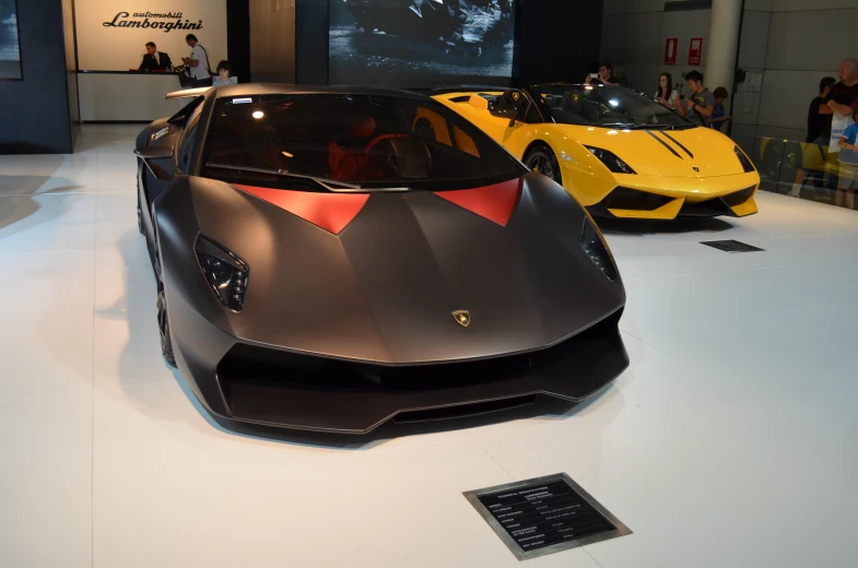 several luxury cars displayed in front of a crowd