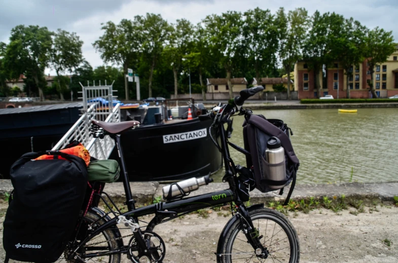 a bike is parked by a harbor while the back pack sits in front