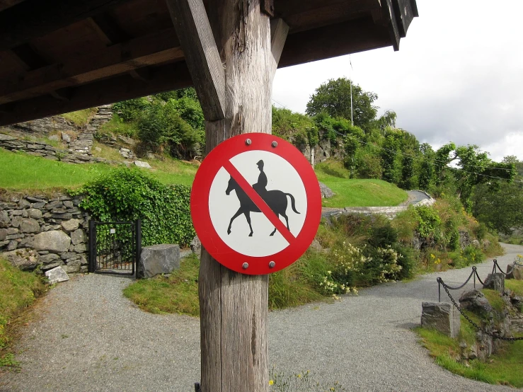 a traffic sign with a horse crossing inside of a forest