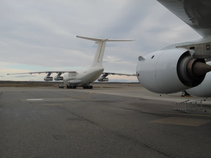 the nose of a large passenger jet next to a parked plane