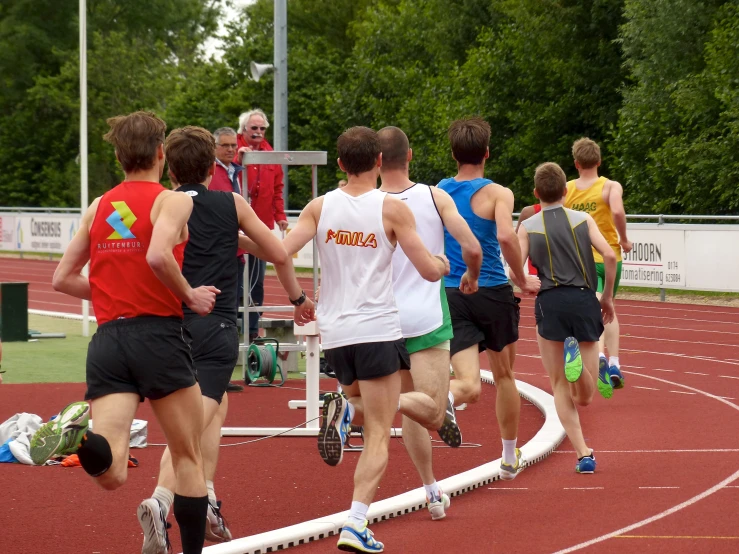 a group of young people running around a track