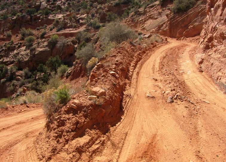 two jeeps that are going up and down a dirt road