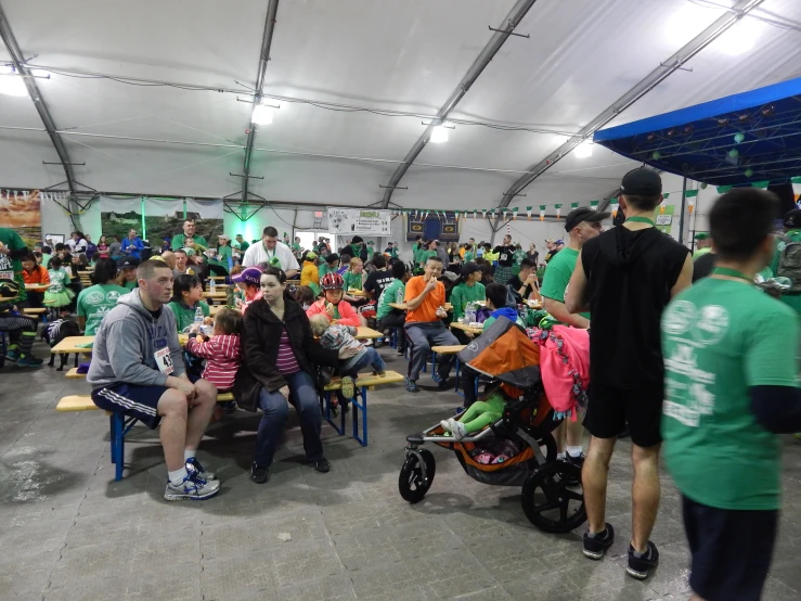 a group of people sitting under tents and tables