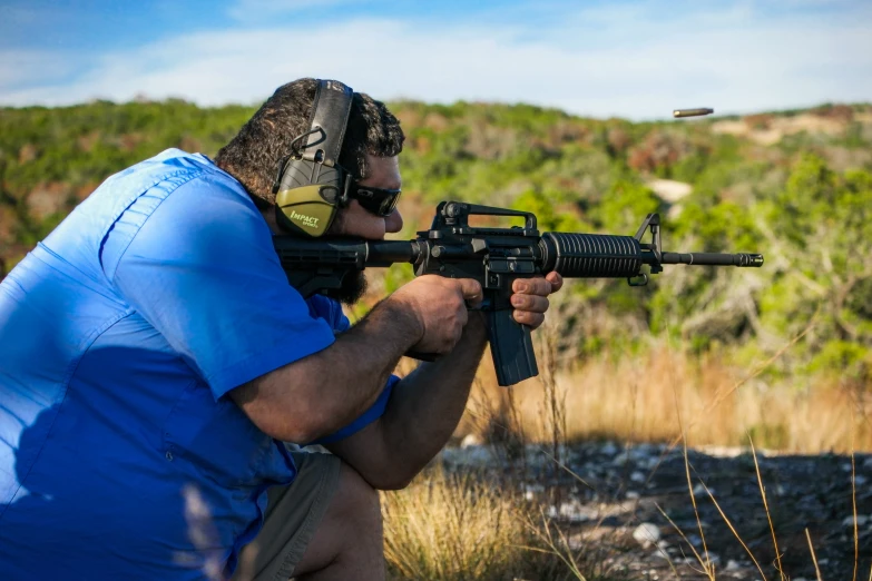 a man taking aim at soing with an ar - 15