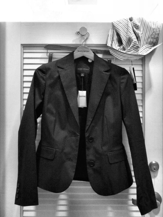 black and white pograph of a suit hanging on a door