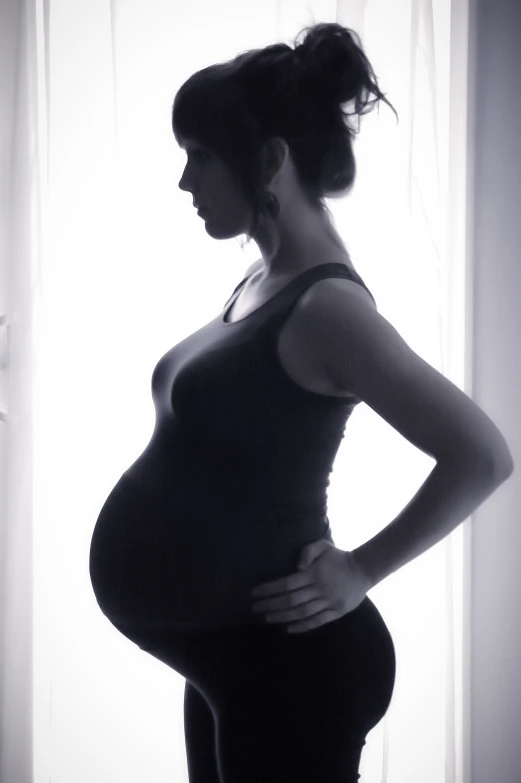 a pregnant woman is looking over her shoulder