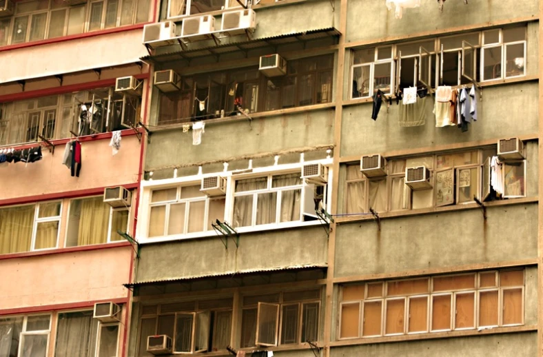 several windows on a building with clothes hanging