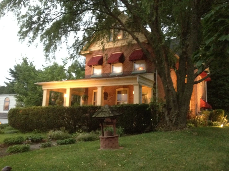 a house with a large tree and lamp on the front