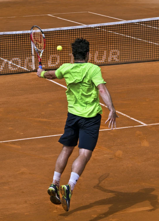 a man hitting a tennis ball with a tennis racquet