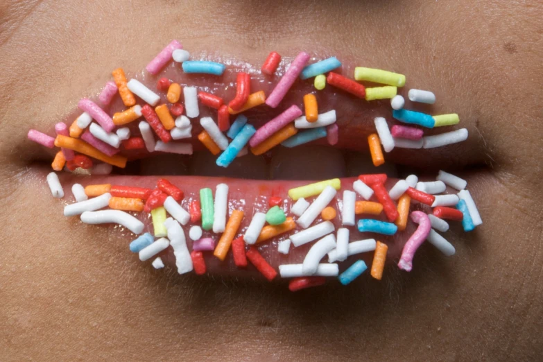a woman's lips with candies in the shape of letters