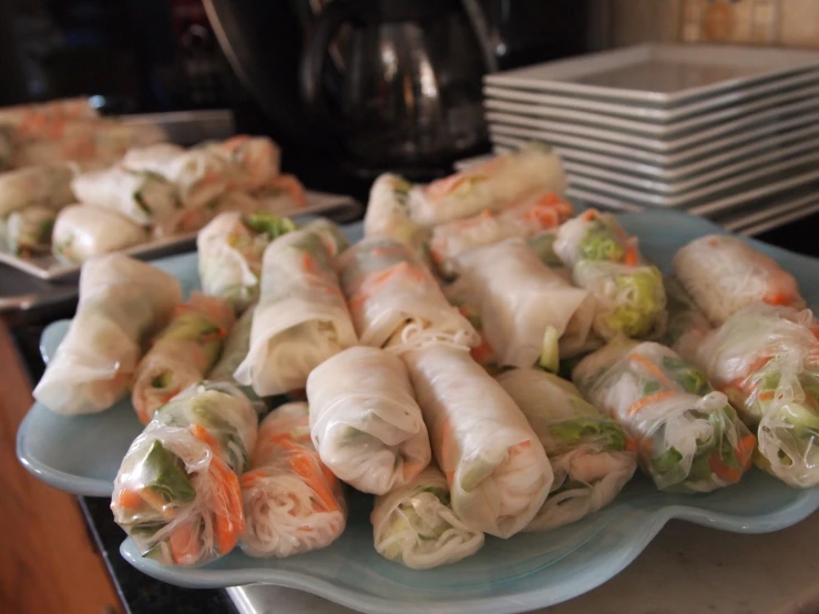 many rolls sitting on a blue plate with white sauce