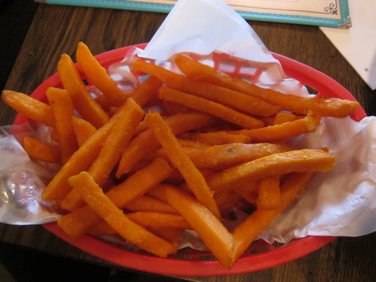 a basket full of french fries on top of a table