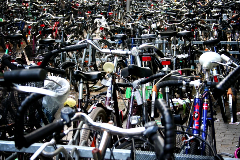 a large amount of bicycles are parked near one another