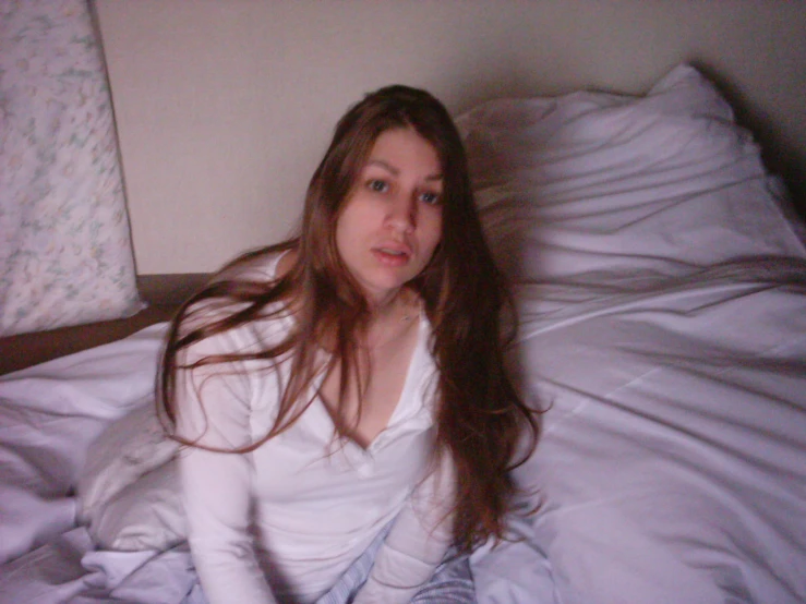 a beautiful young woman laying on top of a bed