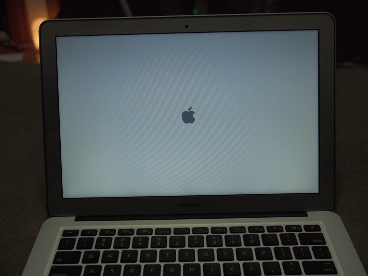 a laptop computer showing a apple logo with no image on screen