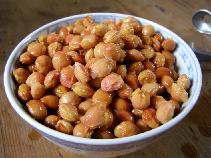 a white bowl filled with a large amount of brown beans