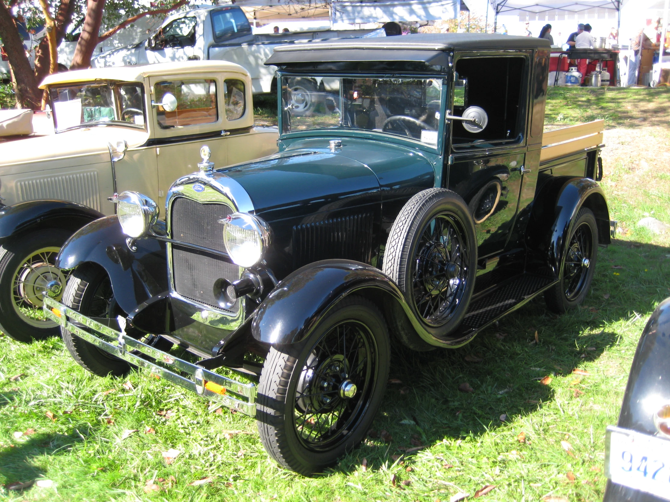 an old - fashioned car with two lights on at a car show