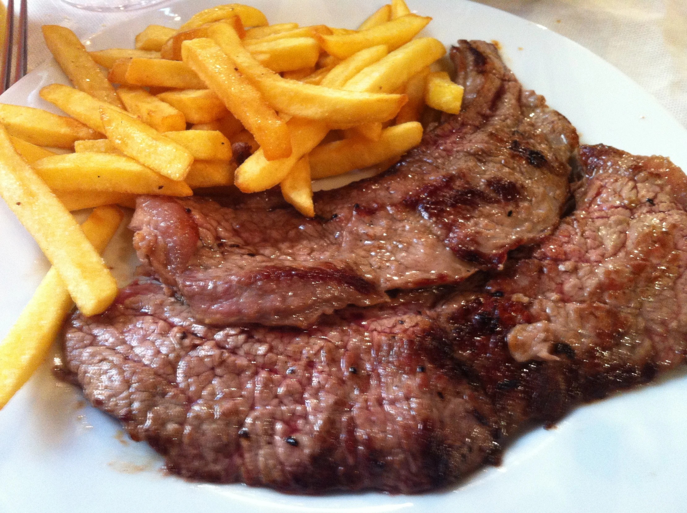 there is a plate with steak, fries and salad