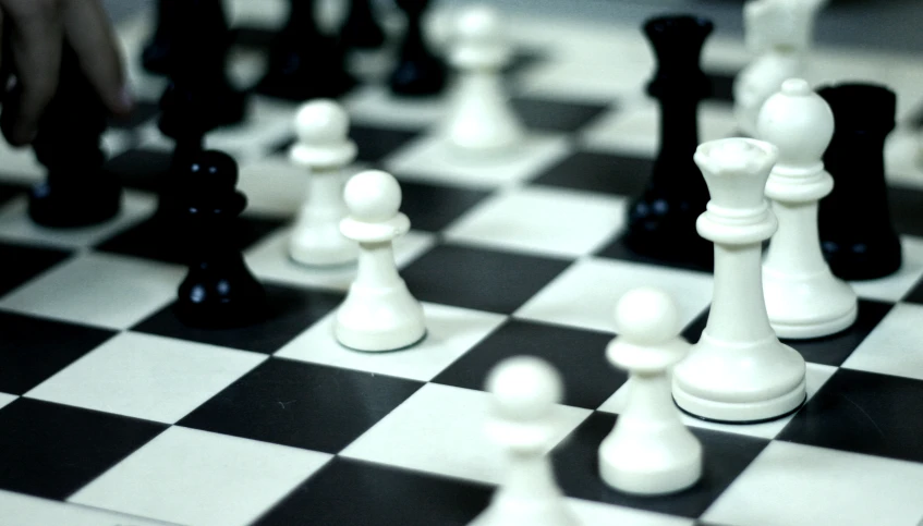 a group of chess pieces are on a black and white checkerboard