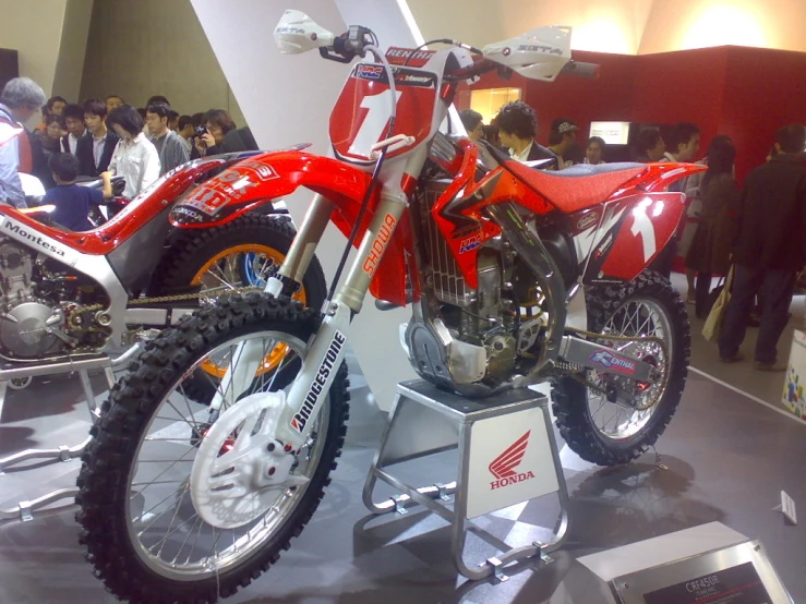 red dirt bike on display at indoor event