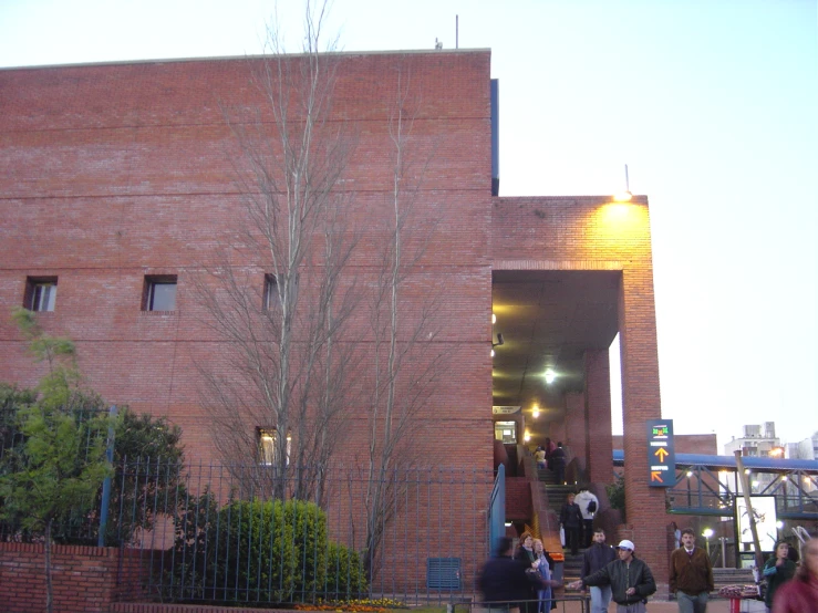 a crowd walking into a brick building with people