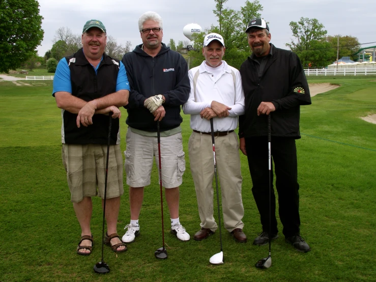 a group of three men standing next to each other holding a ball