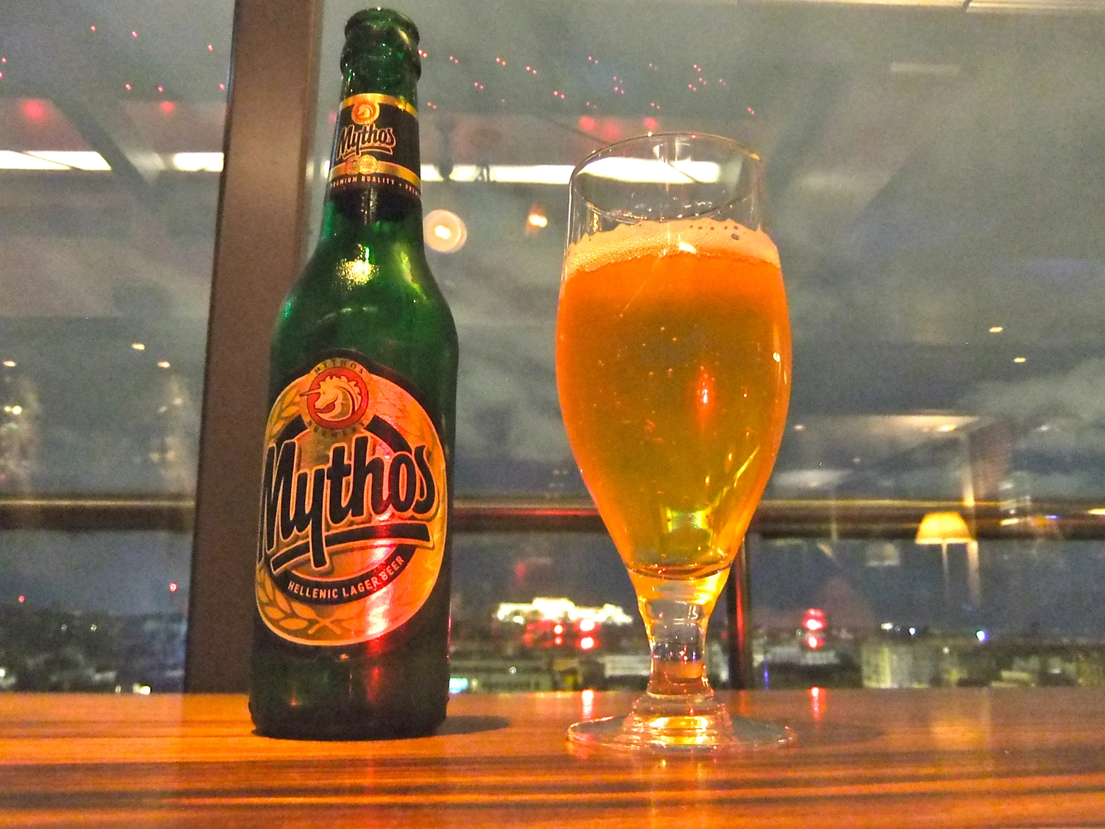 a beer bottle and a glass next to a window