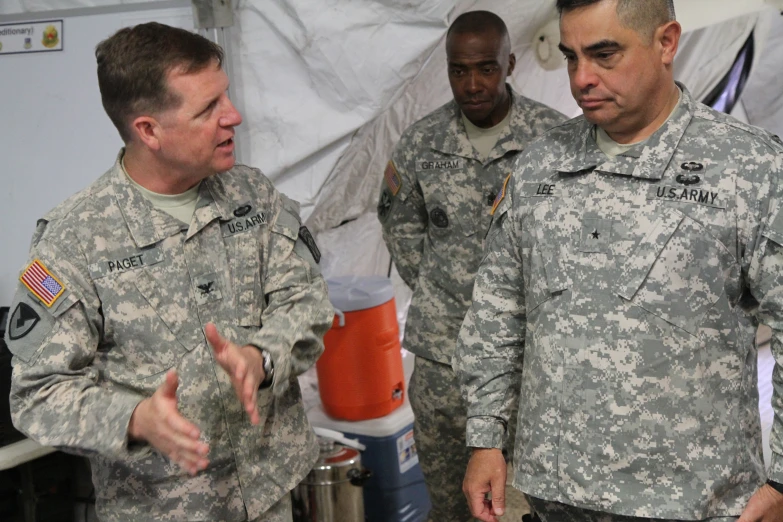 military officials are standing in a tent area