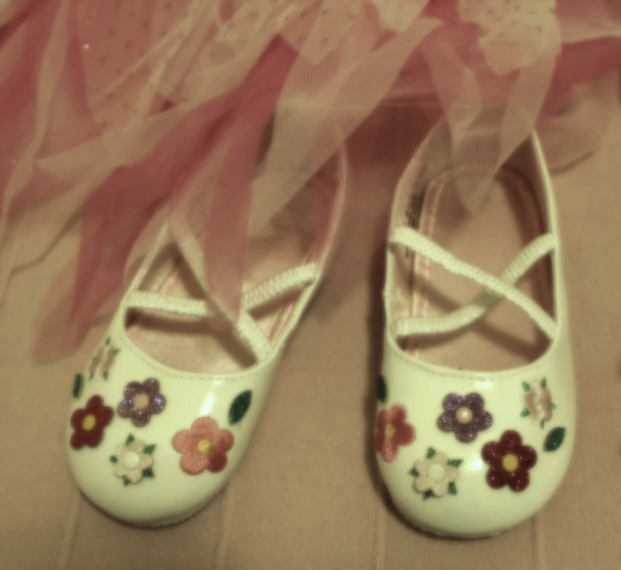 white shoes with pink ribbon are next to a skirt