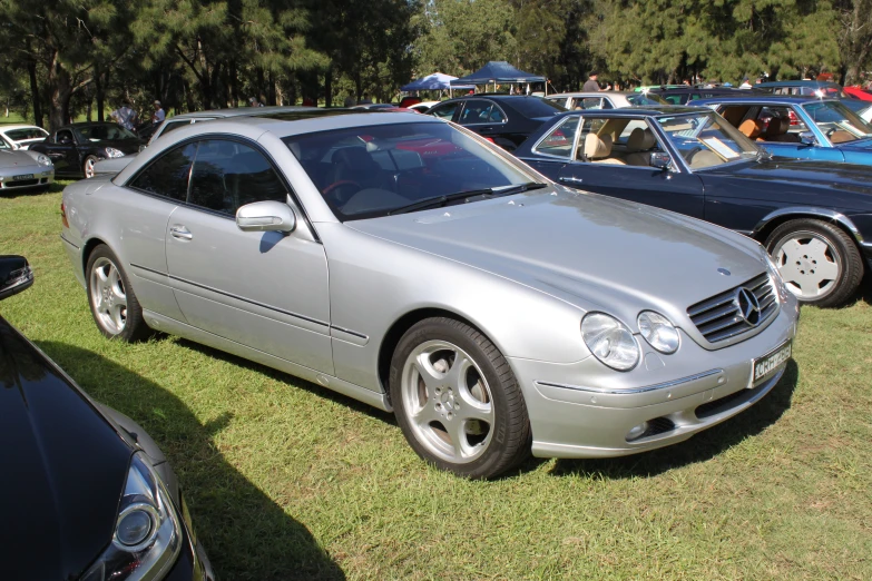 a silver car parked in a grassy area next to other cars