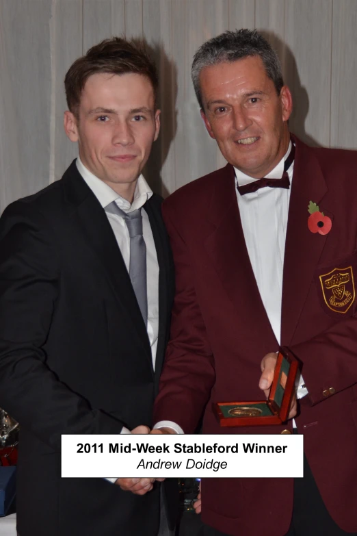 two men, one in a red suit and the other in black tie