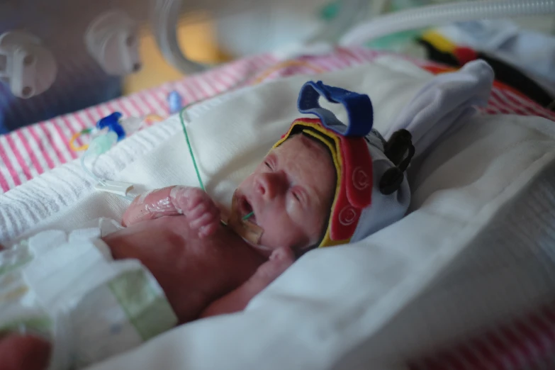 an infant is in a crib looking at a monitor