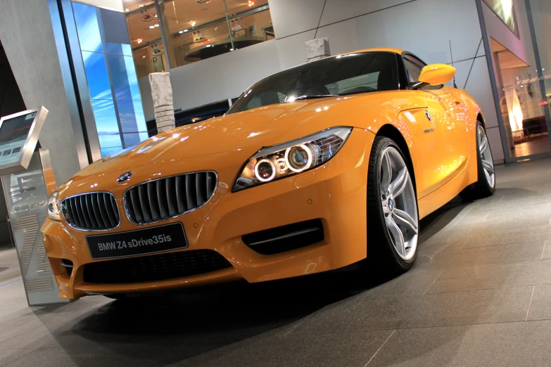 a yellow bmw car is on display at the automobile show