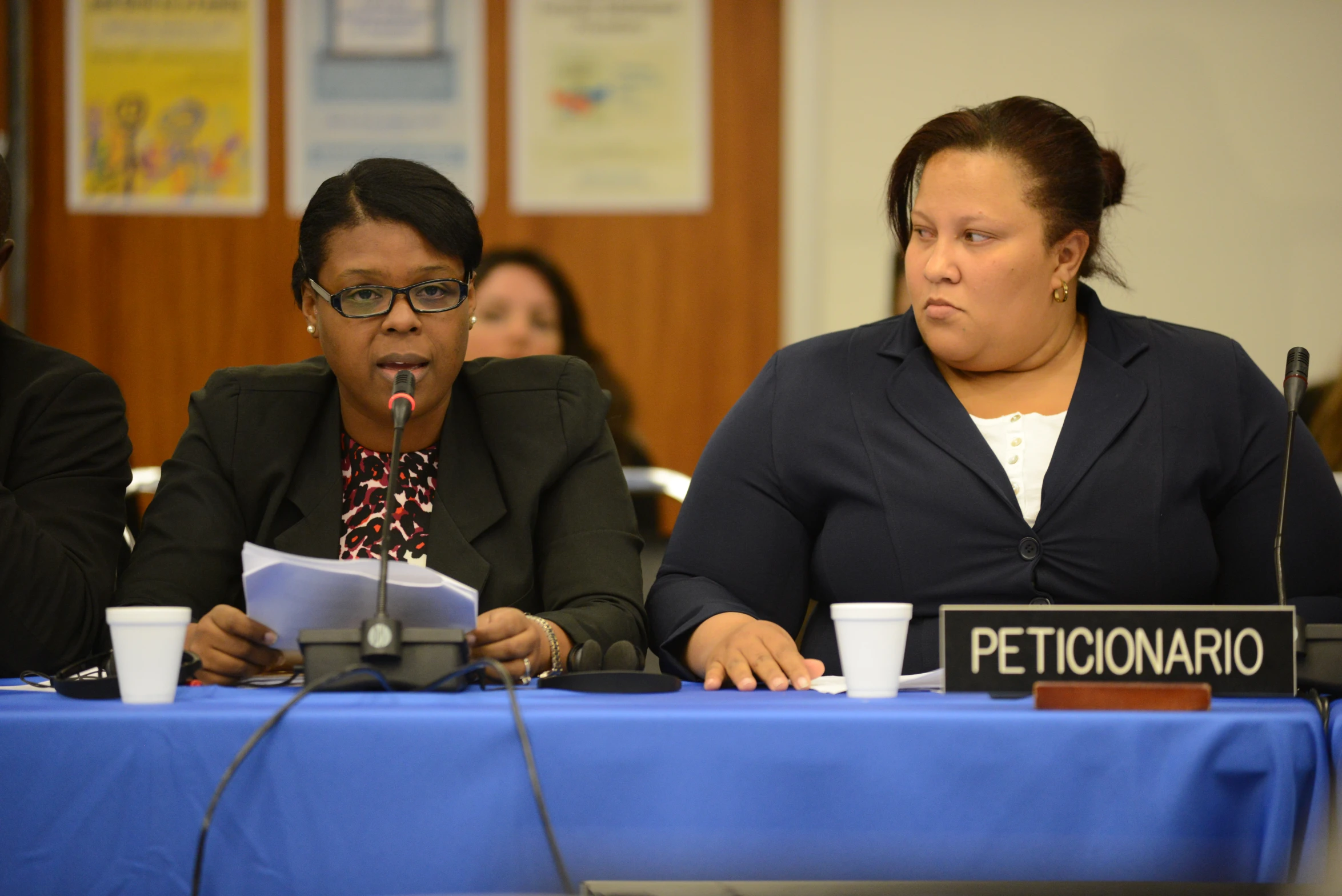 the two woman are sitting down at the table