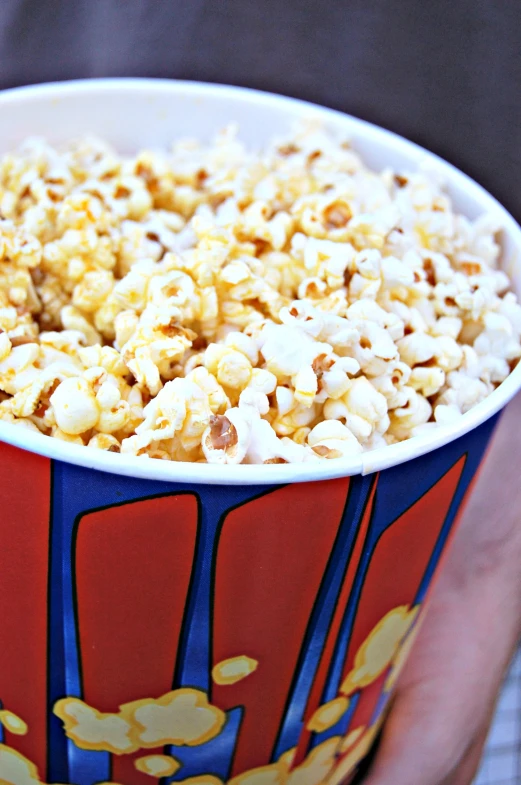 a big red cup filled with lots of popcorn