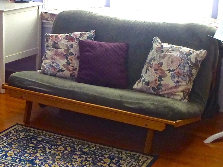 a green couch with several pillows on it