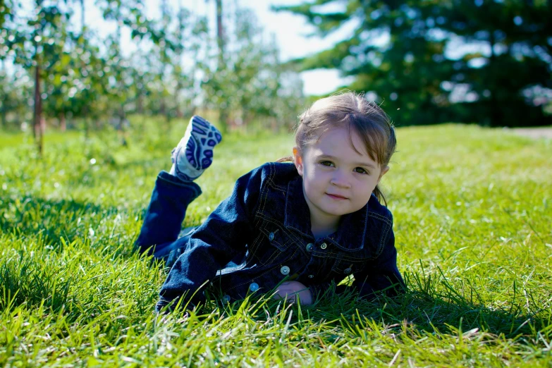 a small child laying on the ground with his hands in the air