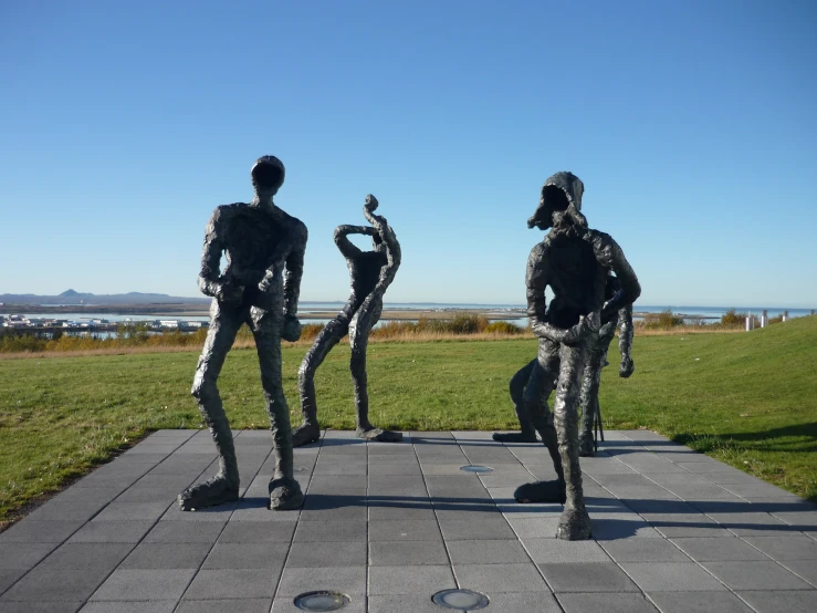 a set of three sculptures sitting in the middle of a park