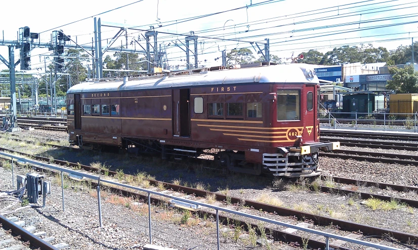 a small train engine on the tracks near a building