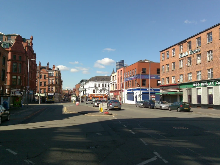 a street with cars, cars and buildings on both sides