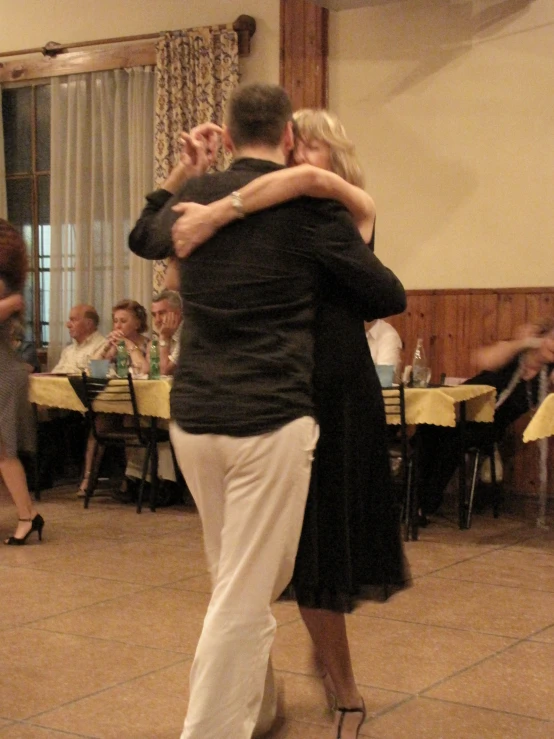 two people standing on top of a dance floor