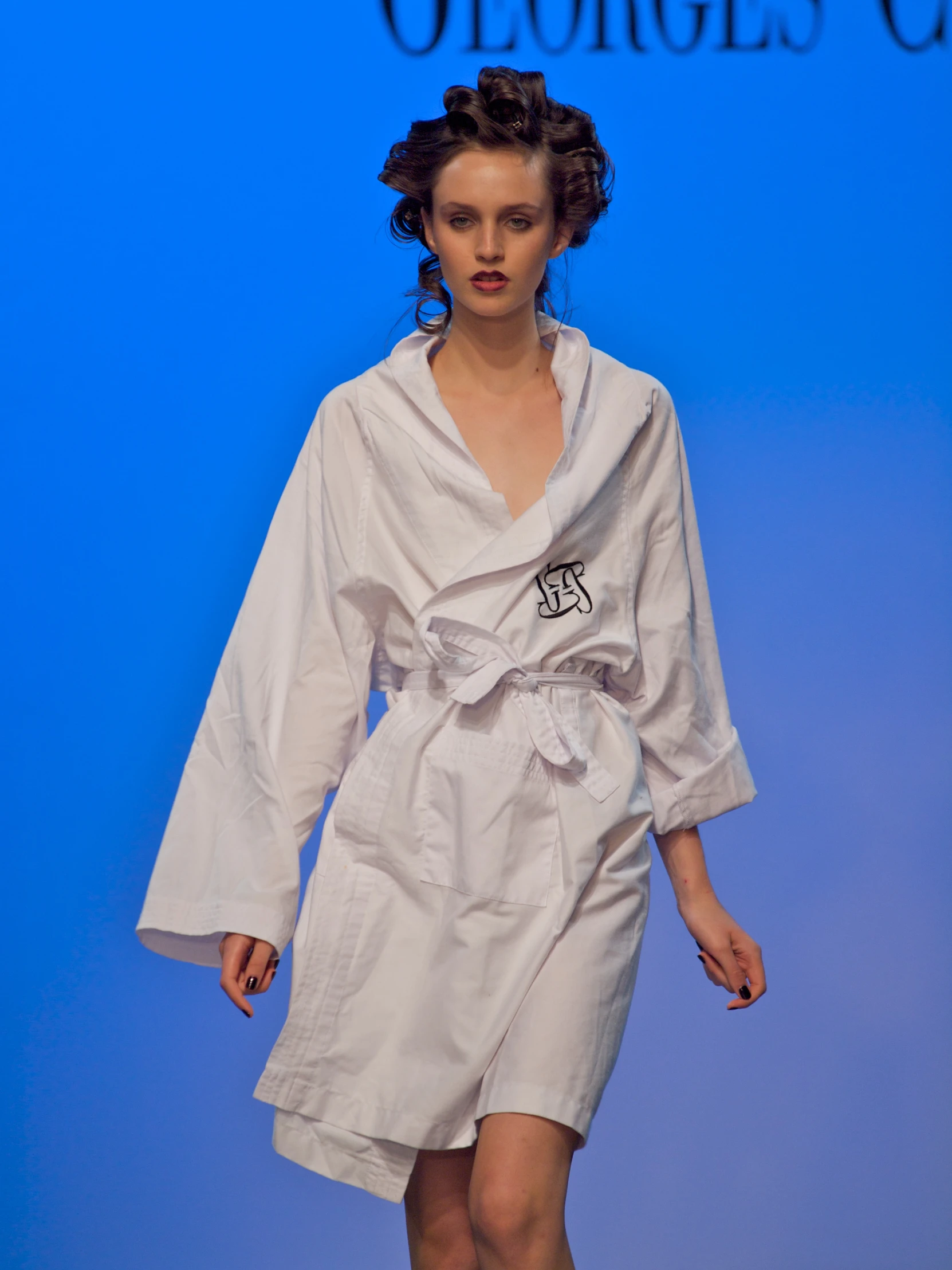 the woman in the robe is walking down the runway