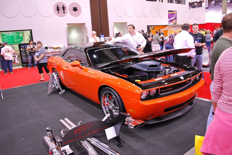 a orange sports car parked on display in a showroom