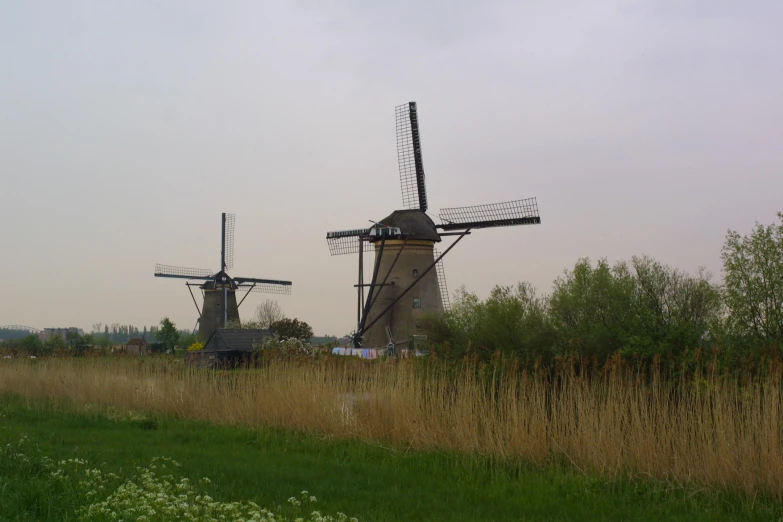 windmills set up along a field side in the middle of an arid area