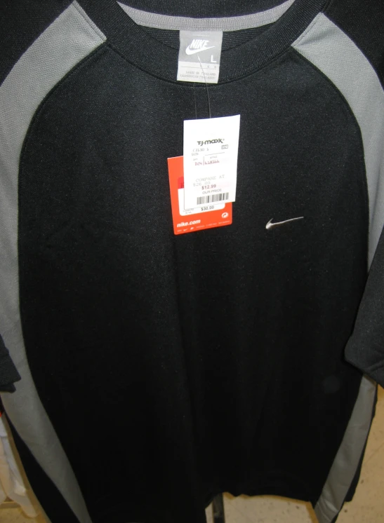 a black and grey sweater with an orange tag