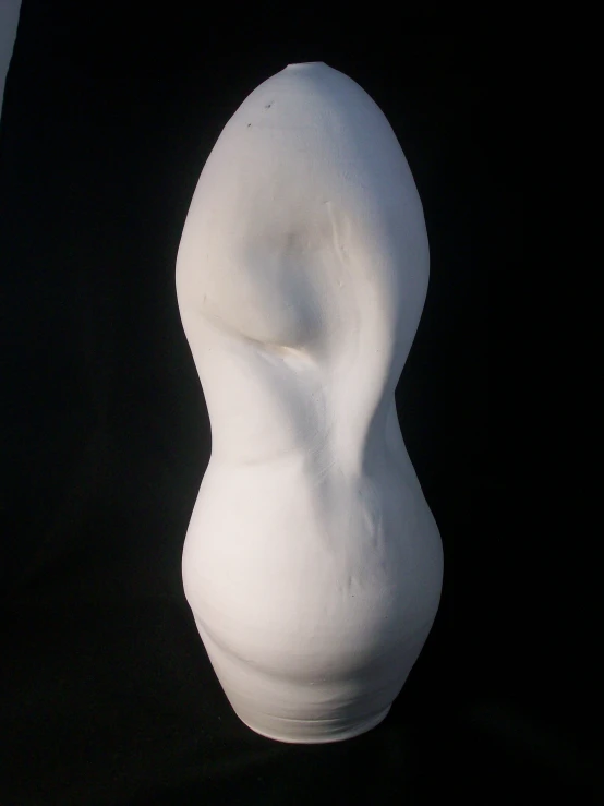 a sculpture of a white human head on a black background